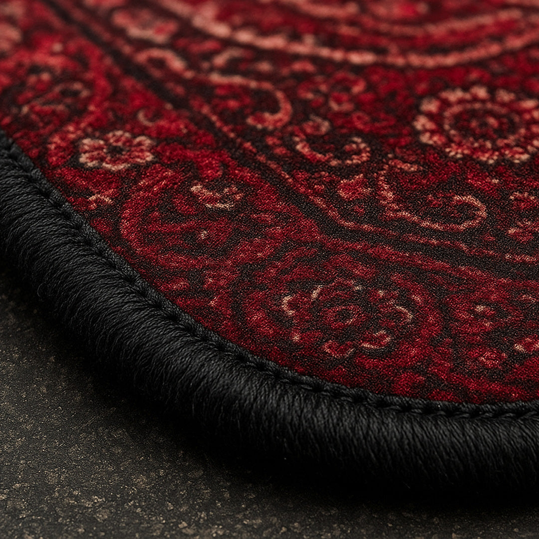 Close-up of a red patterned rug with black border.